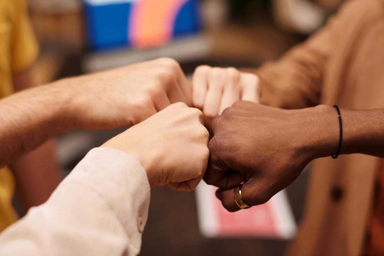 Close-up of a diverse group doing a fist bump, symbolizing teamwork and unity.